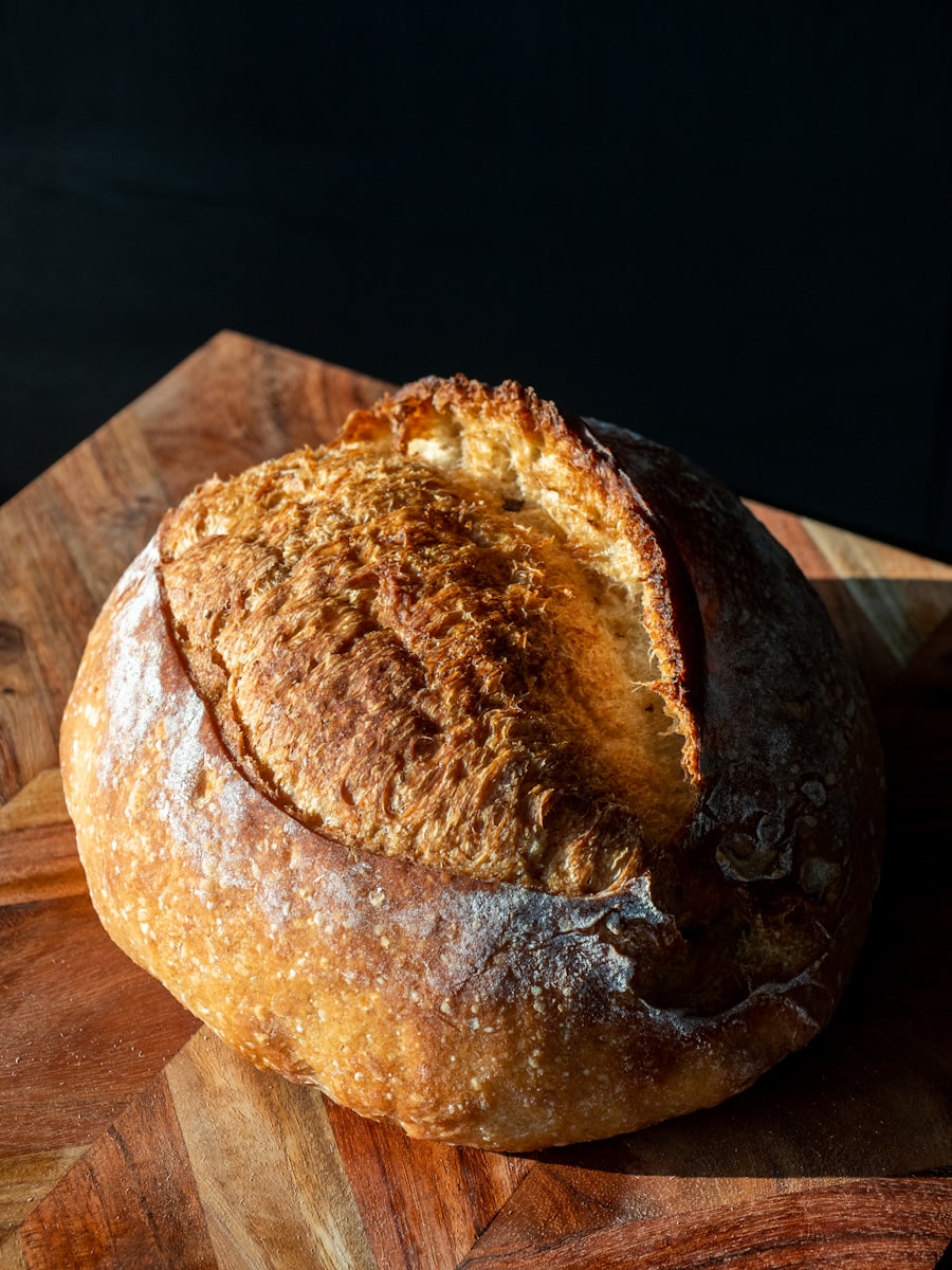 Golden country sourdough boule with a deep hand-scored crust