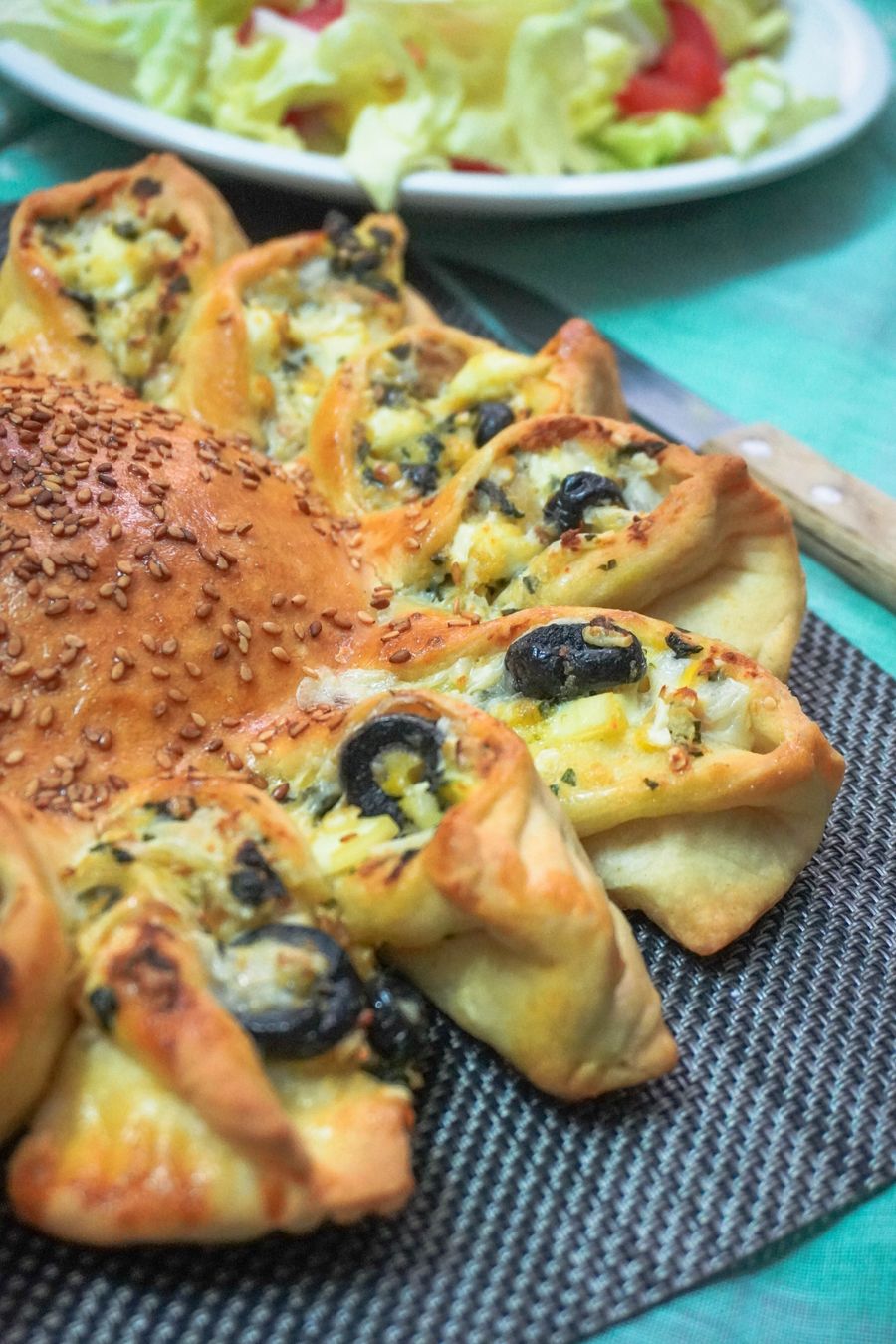 Golden loaf baked with black olives and melting cheese
